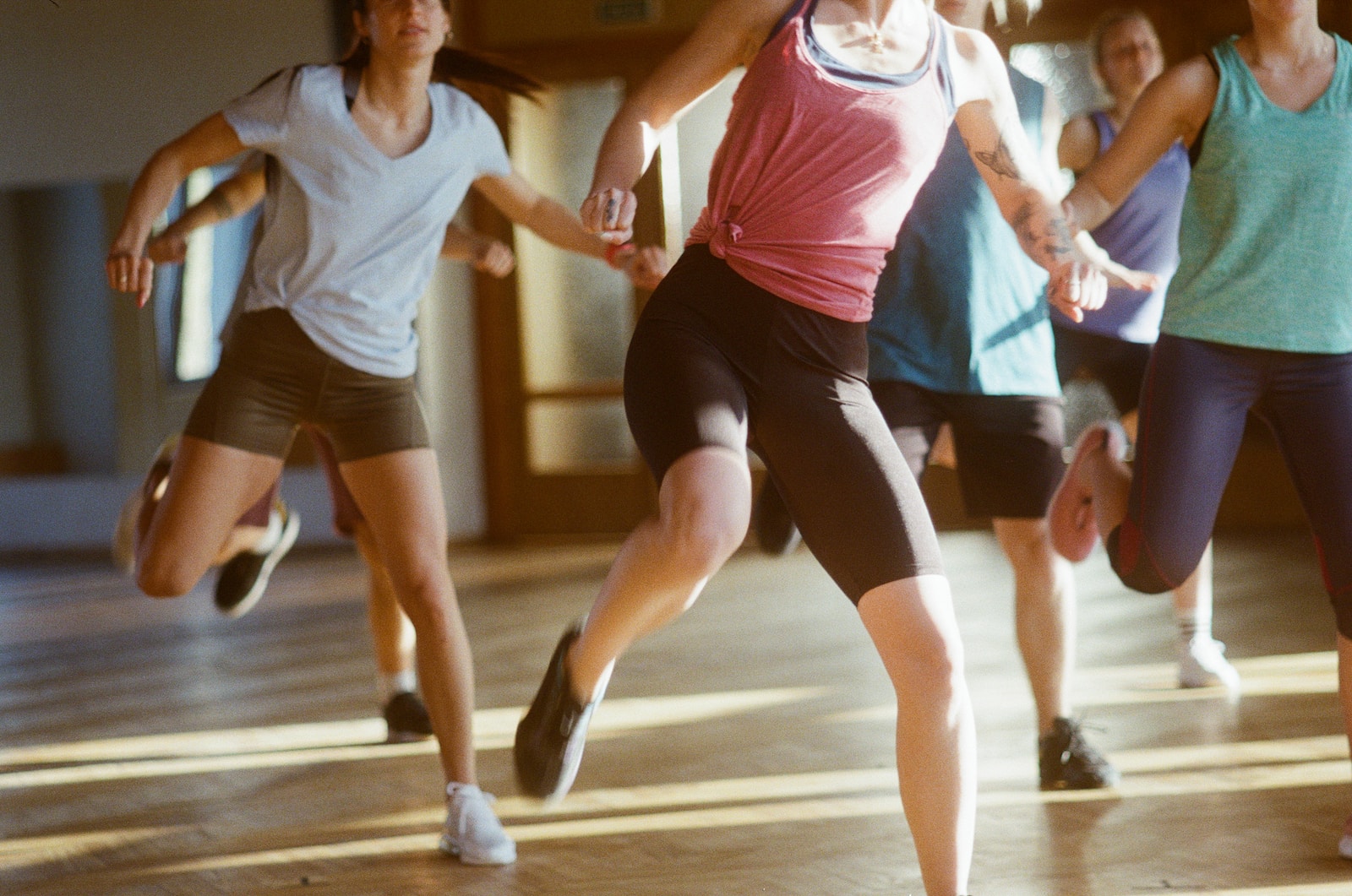 group of women running on brown wooden floor