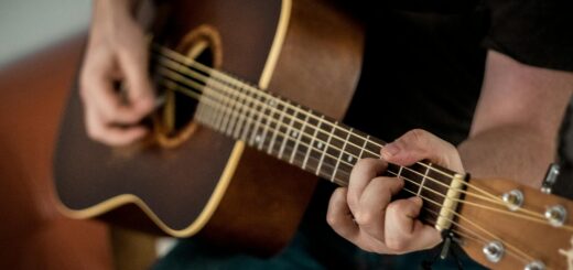 Person Playing Brown Guitar